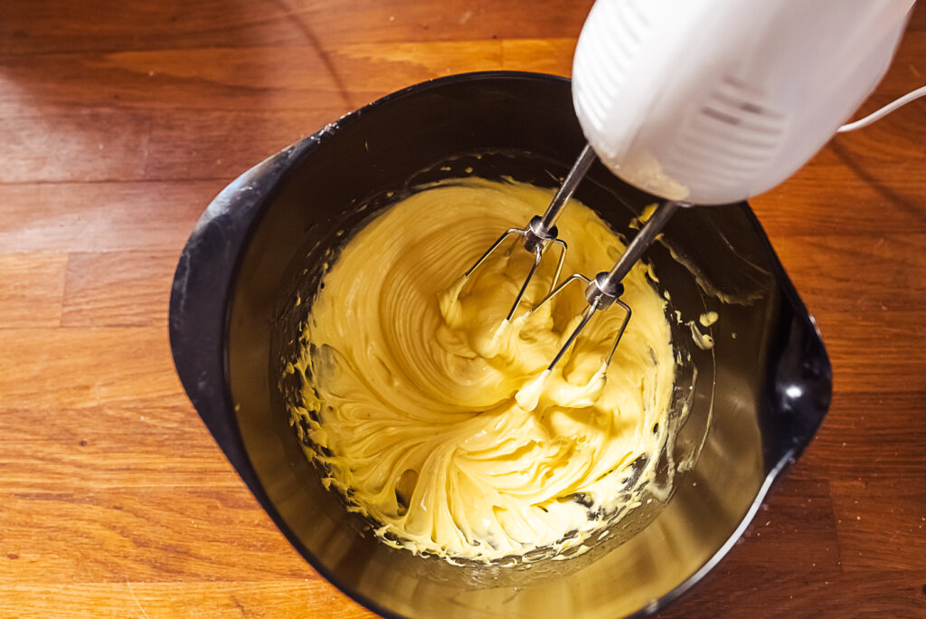 making egg cream frosting for Norwegian almond cake