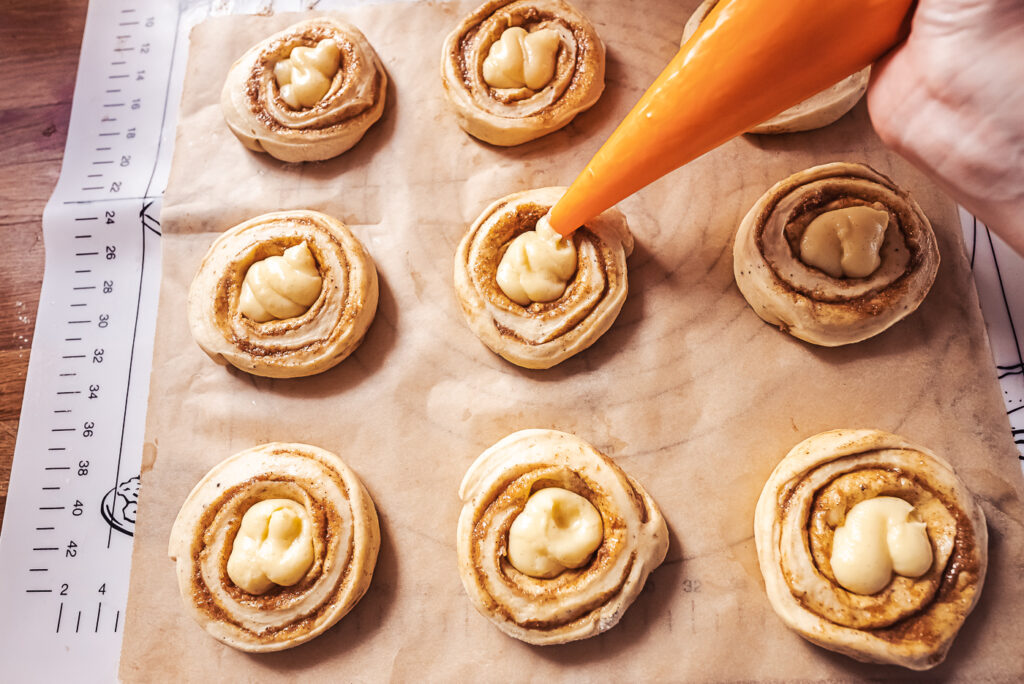 piping vanilla cream into solskinnsboller