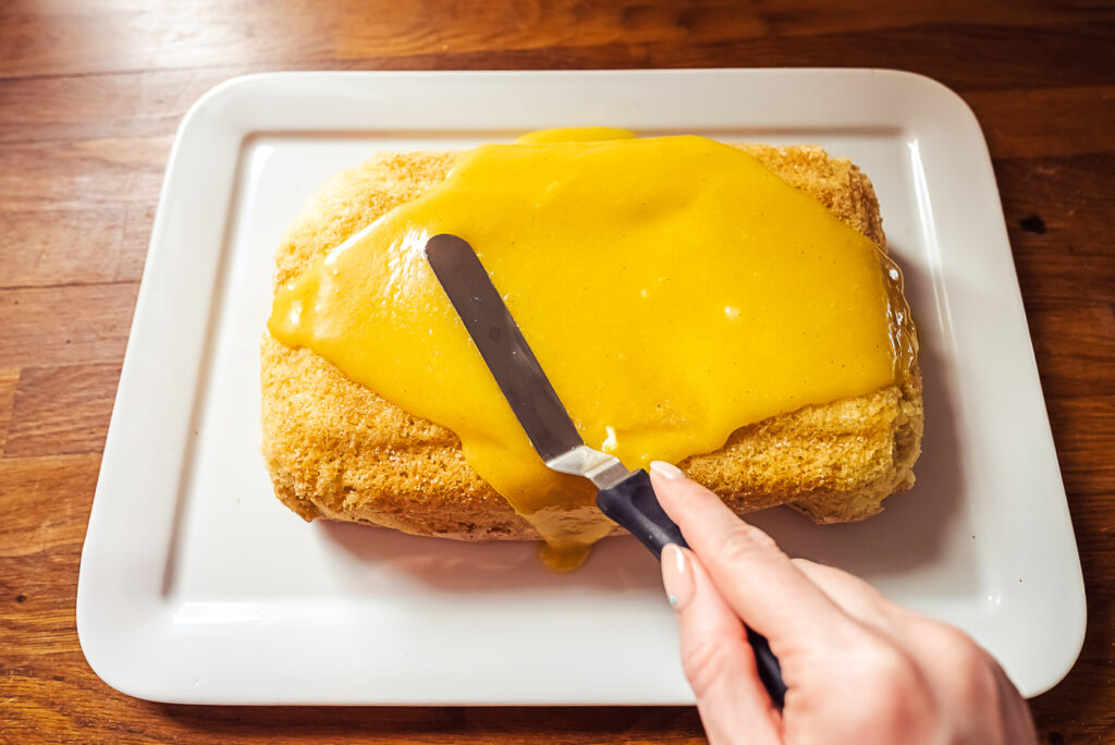 adding glaze to silvia cake