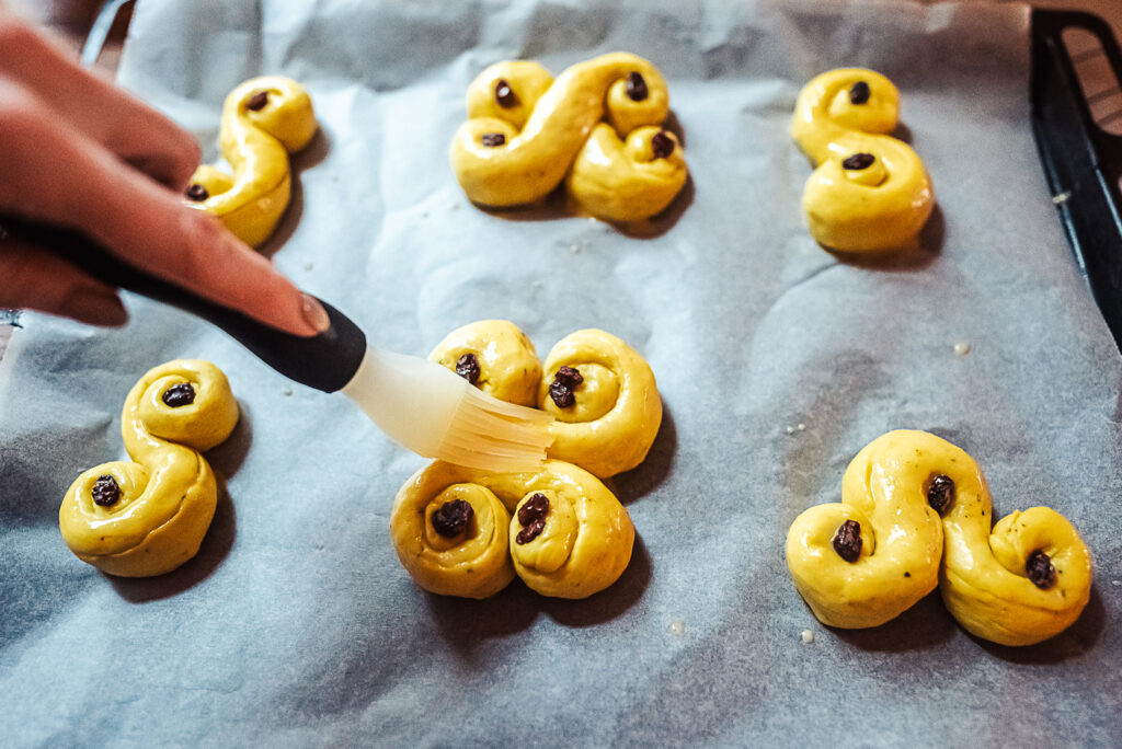 brushing lussekatter with egg wash
