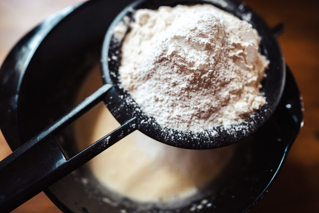sifting dry ingredients into cake batter