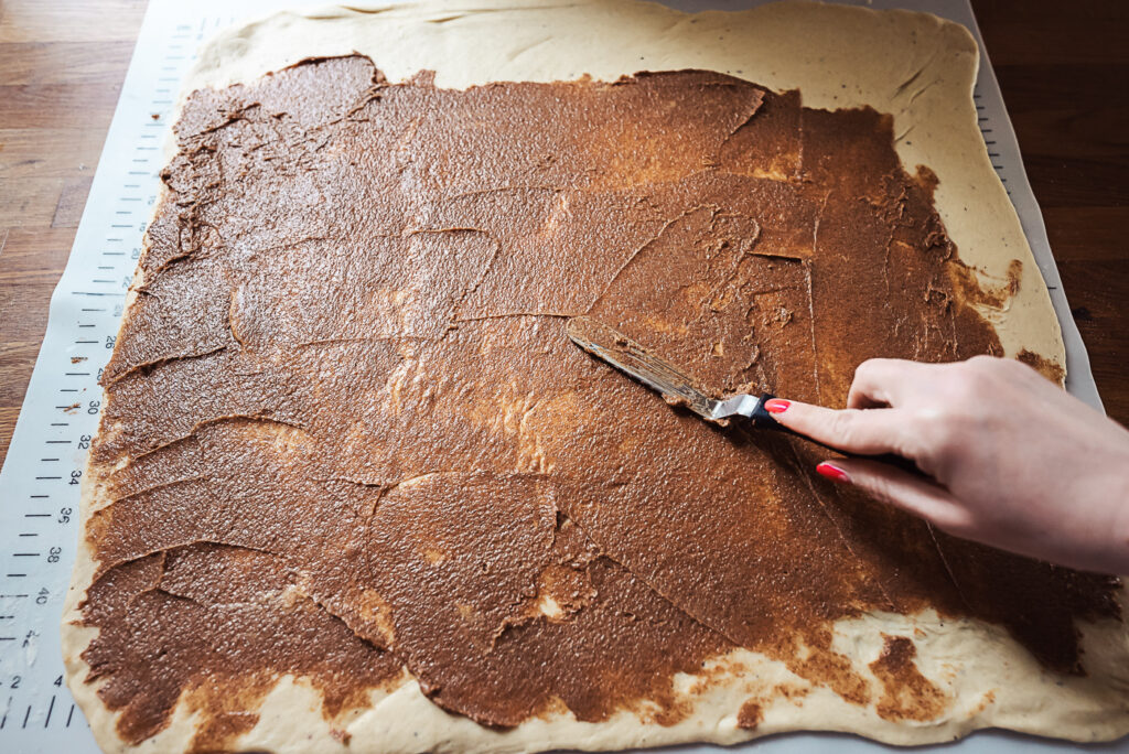 spreading cinnamon sugar and butter on kanelsnegle dough