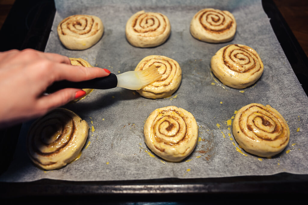 brushing cinnamon rolls with egg wash