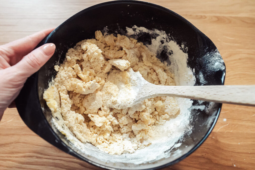 kolasnittar cookie dough in a mixing bowl with wooden spoon