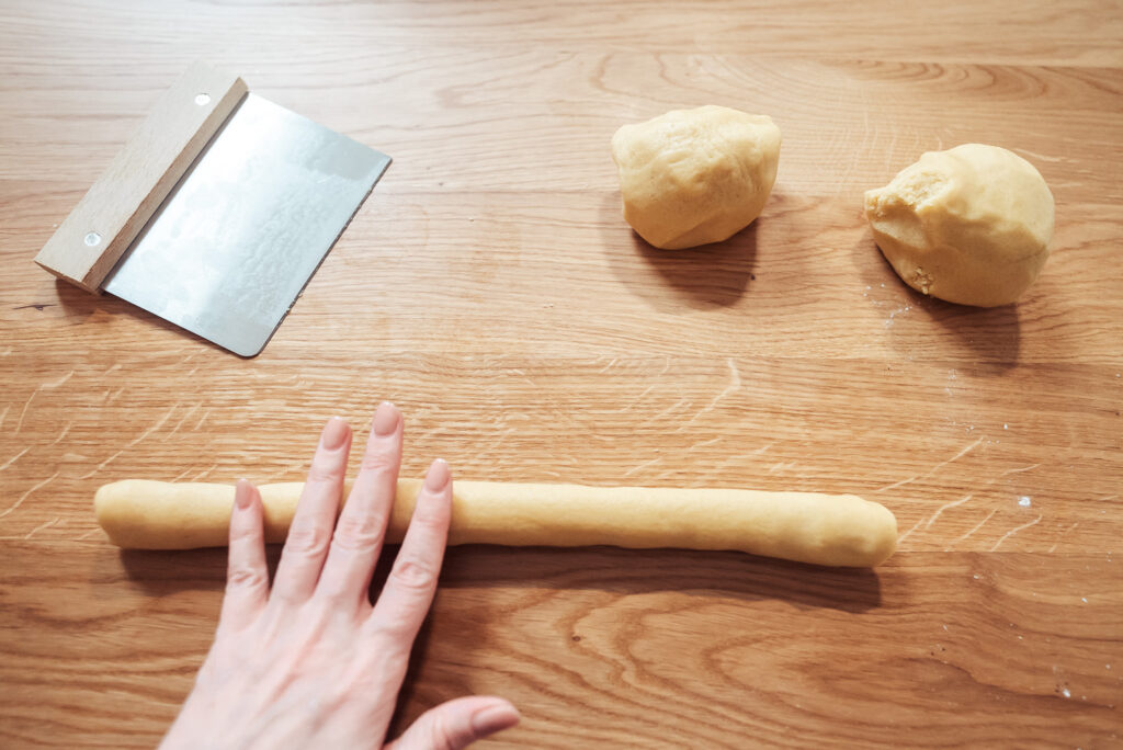 rolling swedish butter cookie dough into logs on counter