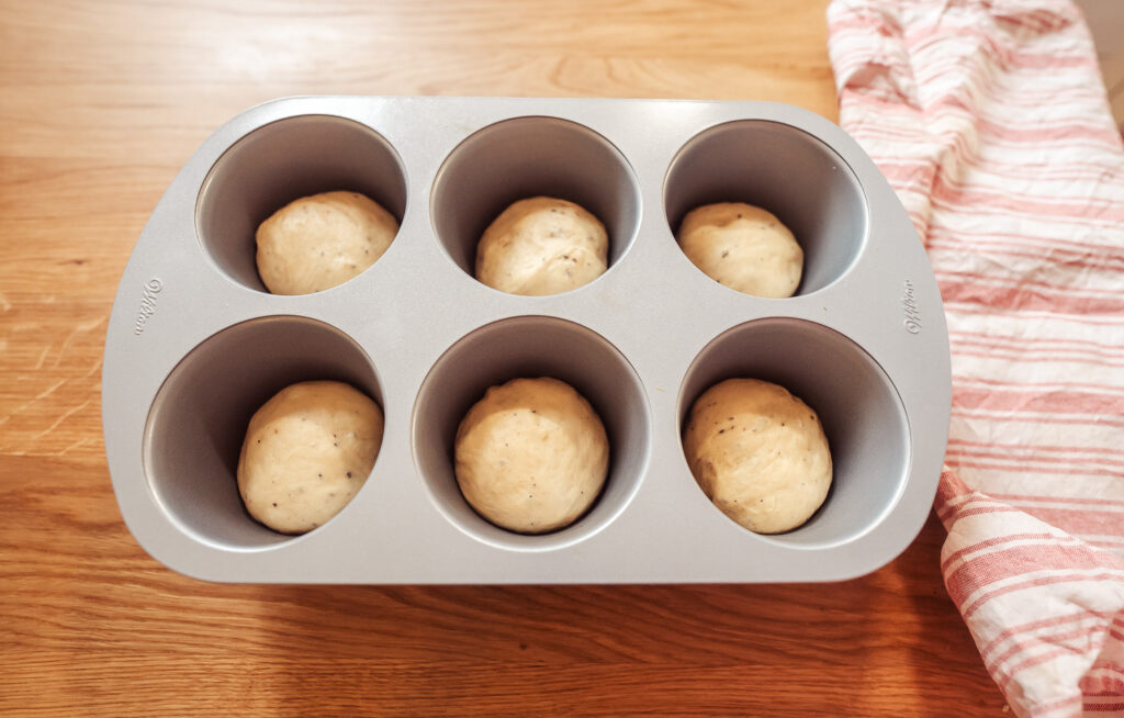 skoleboller dough rising in a muffin form