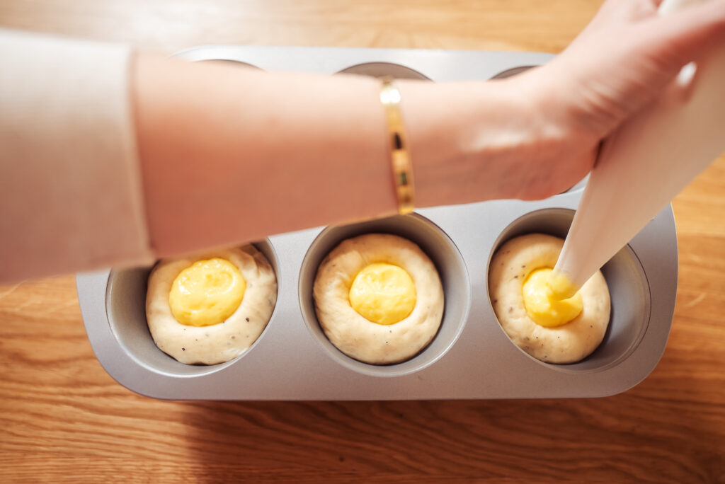 piping vanilla custard into skoleboller buns