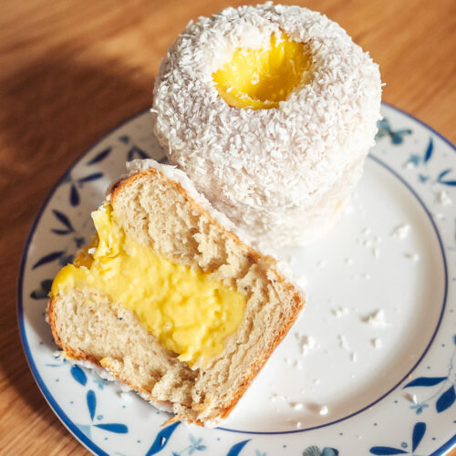tall skoleboller school bread on a plate, one whole bun and one cut in half