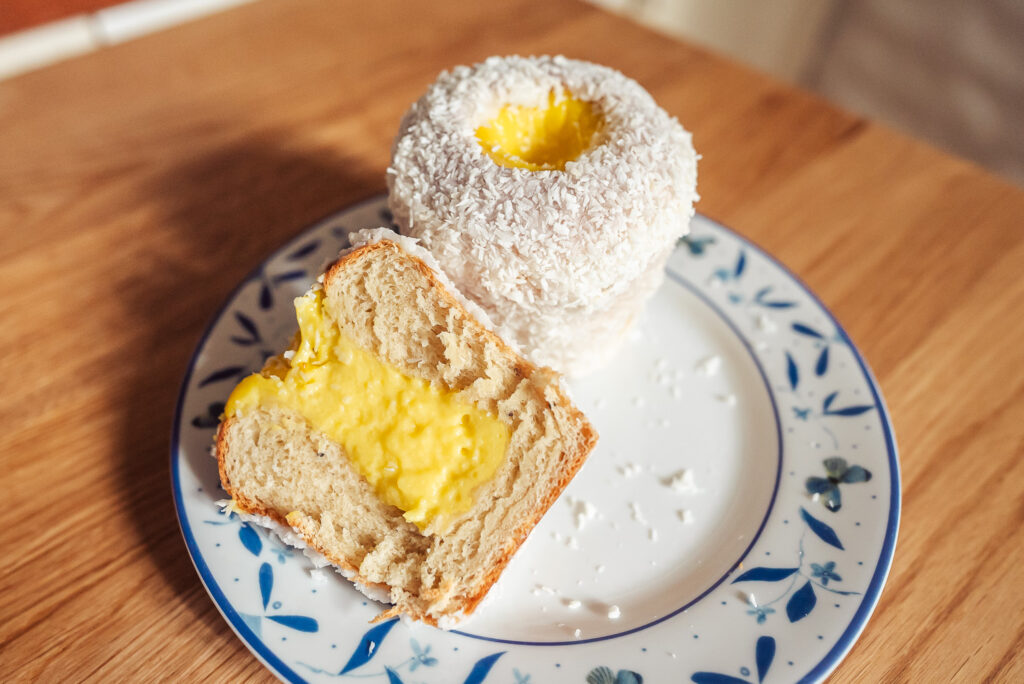 tall skolebrød school bread on a plate, one whole bun and one cut in half