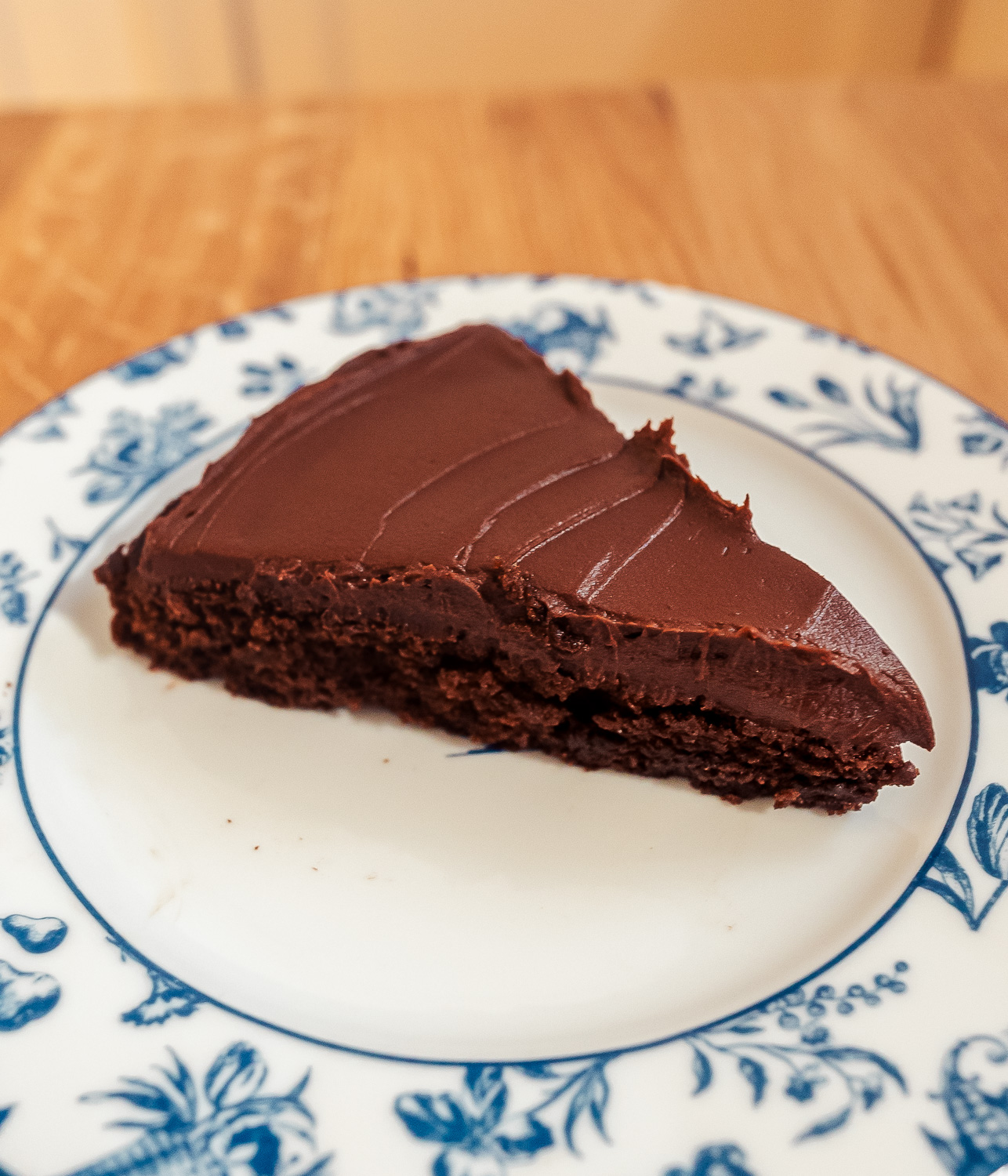 slice of kladdkaka Swedish chocolate cake with dark chocolate and coffee ganache on a blue and white plate
