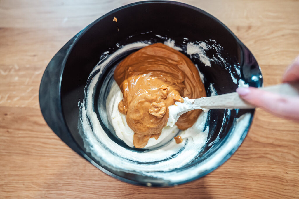 stirring brown cheese into cream cheese to make brown cheese cheesecake filling