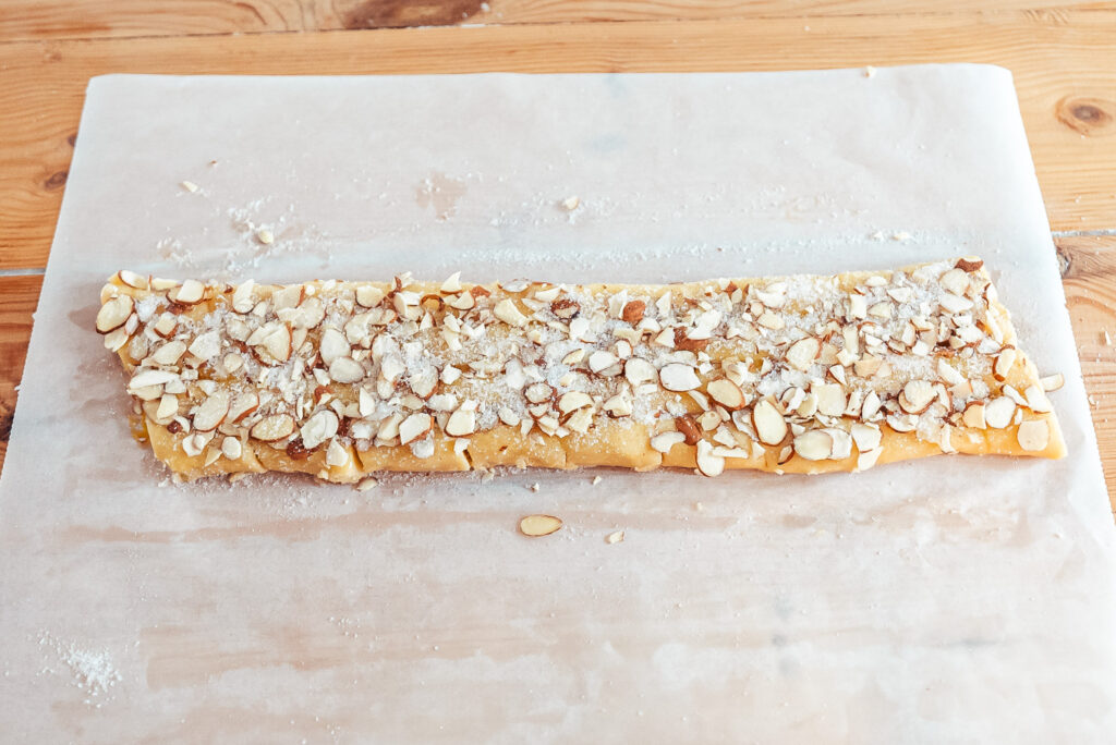 decorating finskbrød cookies with sugar and almonds