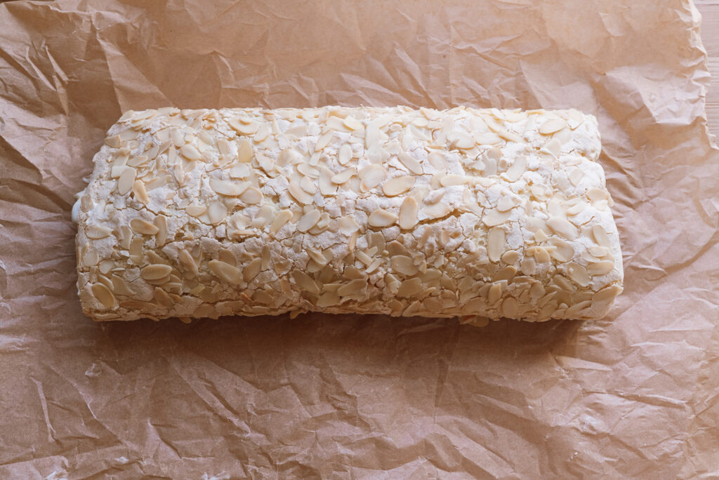 Norwegian budapestkake, rolled verdens beste (kvæfjordkake) with almonds on top