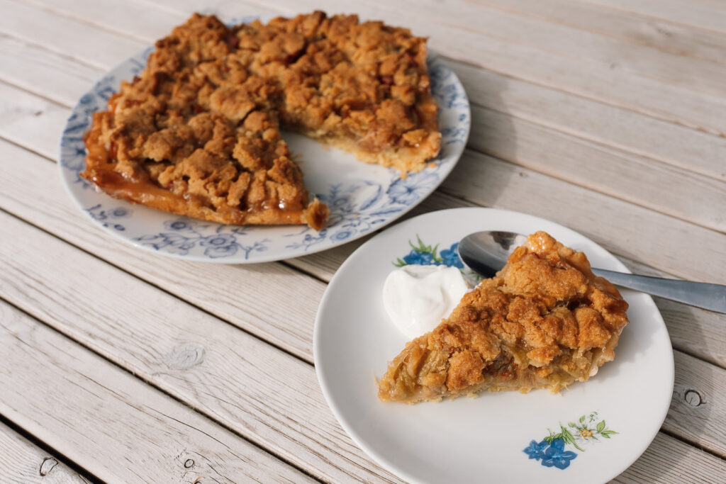 Norwegian rhubarb pie with crumble topping served on a plate with flowers